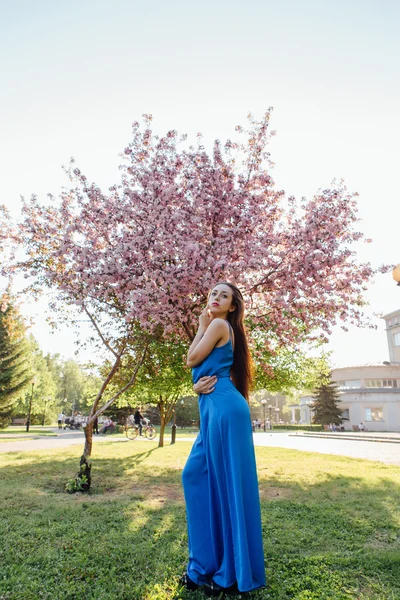 Beautiful young woman standing near the apple tree. — Stock Photo, Image