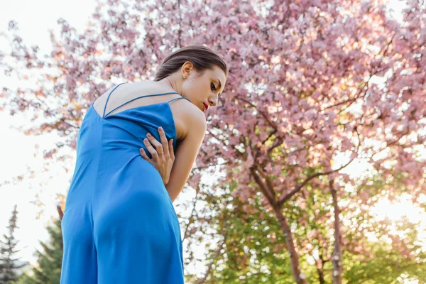 Mooie jonge vrouw die permanent in de buurt van de appelboom. — Stockfoto