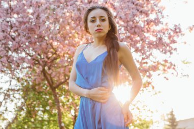 Elma ağacının yanında duran güzel genç kadın.