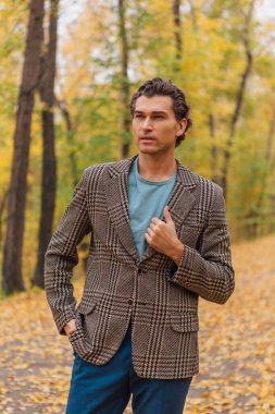 Sonbahar sokağında uzun boylu yakışıklı bir adam.