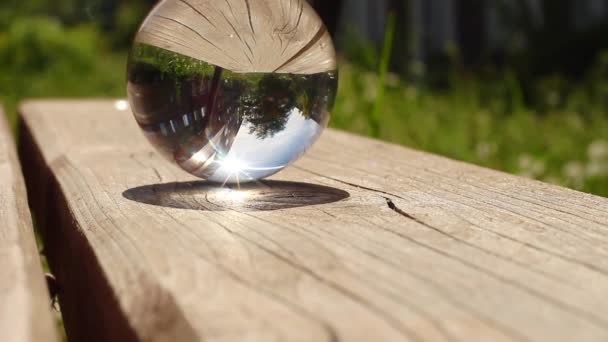 La luce del sole brucia una tavola di legno attraverso la lente sferica — Video Stock