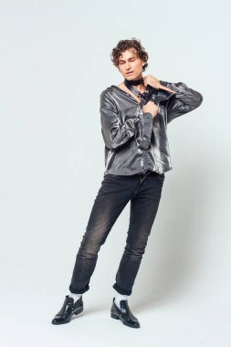 Beyaz arka planda, boynunda kemer olan acımasız yakışıklı bir adam. Bdsm konsepti. Cinsel fetişizm.