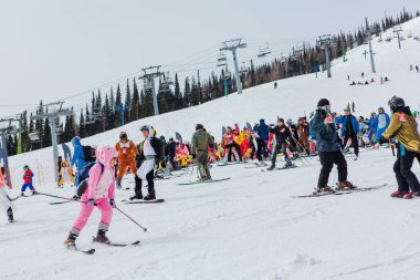 Sheregesh, Kemerovo bölgesi, Rusya - 3 Nisan 2021: Grelka Festivali kayak ve snowboard sporcuları için bir spor ve eğlence etkinliğidir. Karnaval kostümlü insanlar kayak ve snowboard yapıyor..