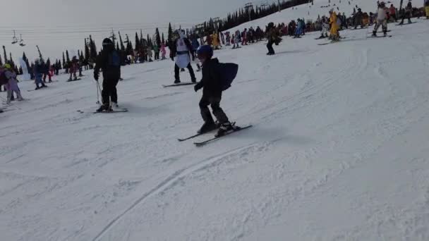 Sheregesh, regio Kemerovo, Rusland - 03 april 2021: Grelka Fest in Sheregesh. Mensen in carnaval kostuums op de sneeuw piste rijden skiën en snowboard. — Stockvideo