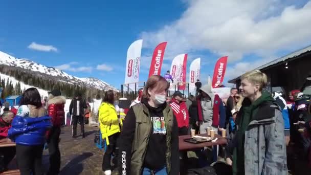 Шерегеш, Кемеровская область, Россия - 03 апреля 2021 года: Молодые лыжники, вечеринка сноубордистов на горнолыжном курорте Шерегеш. Люди танцуют и веселятся — стоковое видео