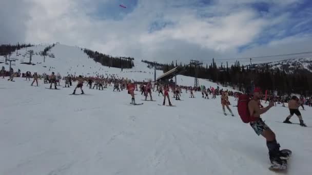 Sheregesh, Kemerovo region, Ryssland - 17 april 2021: Grelka Fest är en sport- och nöjesaktivitet för skid- och snowboardåkare i bikini. Folkmassa människor ridning snowboard och mountain ski — Stockvideo