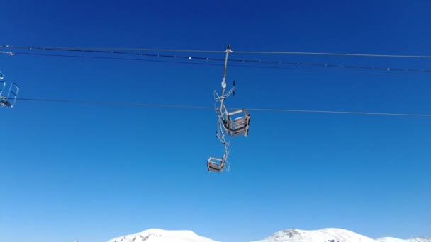 在阳光明媚的冬日里，在山顶上移动滑雪椅升降站 — 图库视频影像