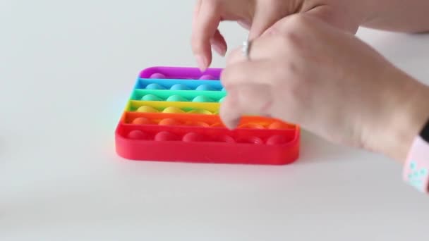 Manos de una mujer jugando con antiestrés pop it toy. — Vídeos de Stock