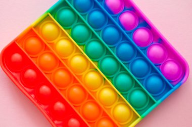 Gökkuşağı duyusal hareketlerini pembe arka planda izole et. Yeni moda silikon oyuncak. Patlayan baloncuk silikon oyuncakları.