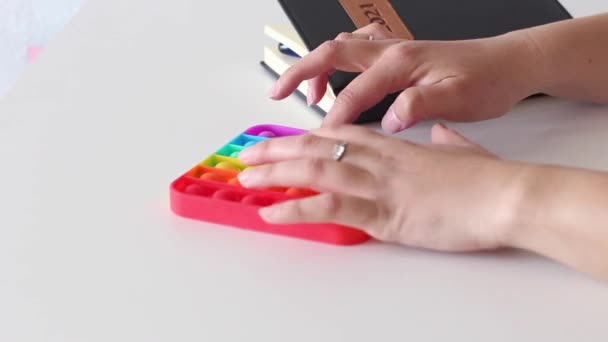 Manos de una mujer jugando con antiestrés pop it toy. — Vídeos de Stock