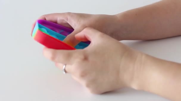 Manos de una mujer jugando con antiestrés pop it toy. — Vídeos de Stock