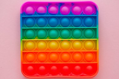 Renkli anti-stres oyuncağını pembe arka plana yerleştir..