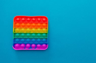 Renkli anti-stres oyuncağını mavi arka plana yerleştir..