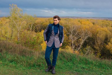 Uzun boylu yakışıklı bir adam fırtınadan önce sarı sonbahar ormanında yürüyordu.