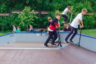 Novokuznetsk, Rusya - 19 Temmuz 2021: Bir grup genç, ekstrem bir parkta scooter kullanıyor. Açık havada ekstrem sporlar eğitimi.