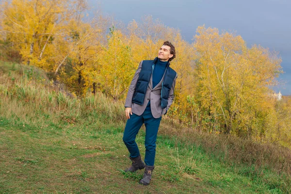 嵐の前に丘の上の黄色の秋の森の中を歩く背の高いハンサムな男 — ストック写真