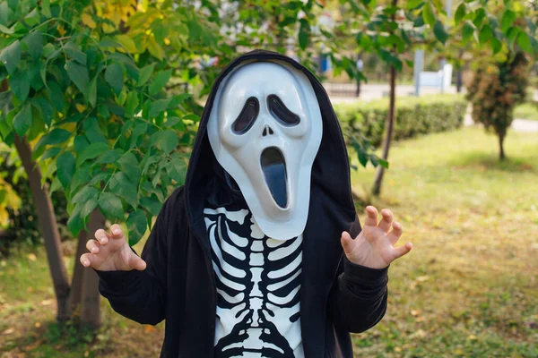 Niño con un disfraz de esqueleto y máscara de grito está listo para celebrar Halloween. — Foto de Stock
