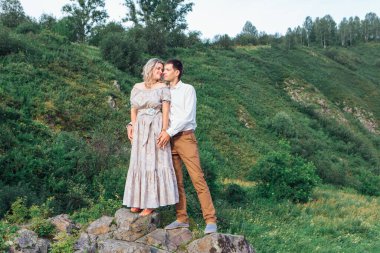 Nehrin kıyısında kayalıklarda duran güzel, aşık bir çift..