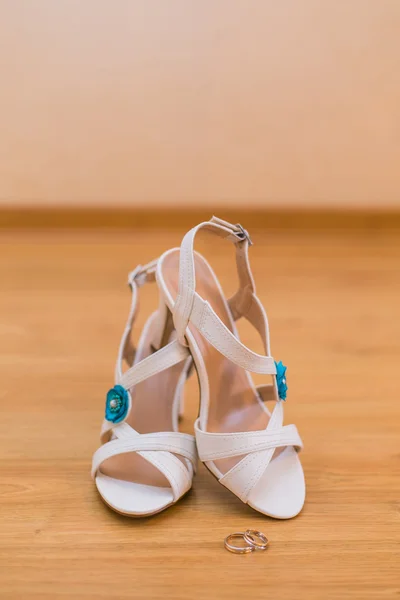 Close up di scarpe da sposa e anelli d'oro — Foto Stock