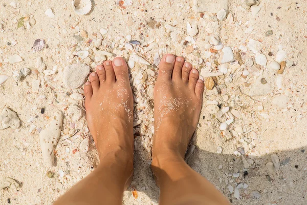 Vrouw blote voeten op het strand. — Stockfoto