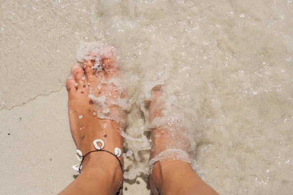 Vrouw blote voeten op het strand. — Stockfoto