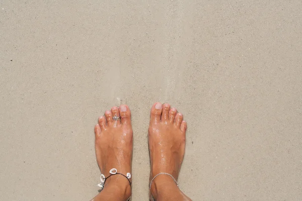 Žena je bosé nohy na pláži. — Stock fotografie