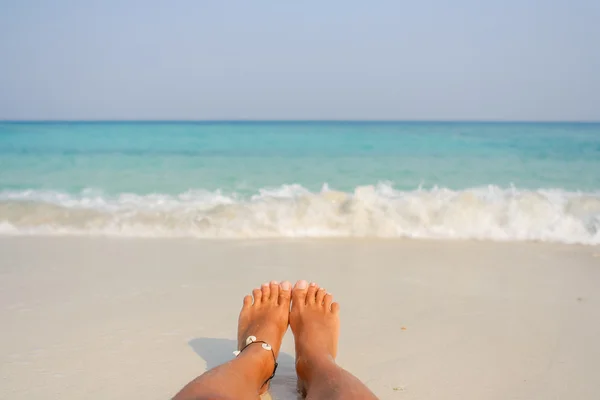 Vrouw blote voeten op het strand. — Stockfoto