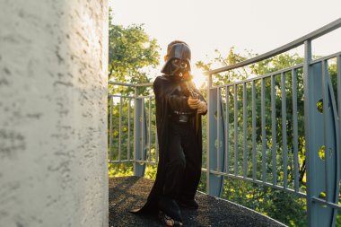 Çocuk bir kostüm Darth Vader kılıç ile.
