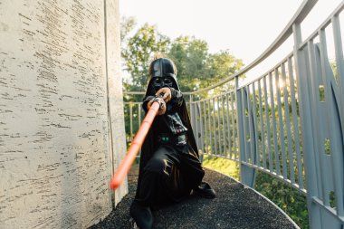 Çocuk bir kostüm Darth Vader kılıç ile.