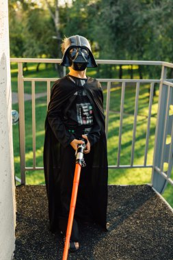 Çocuk bir kostüm Darth Vader kılıç ile.