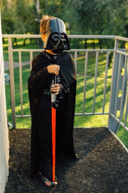 Çocuk bir kostüm Darth Vader kılıç ile.