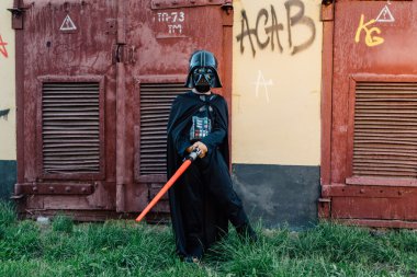 Çocuk bir kostüm Darth Vader kılıç ile.
