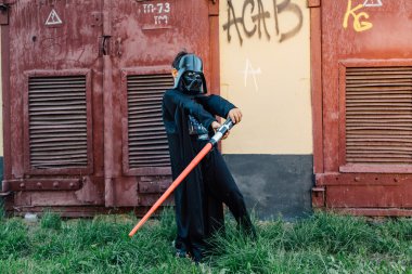 Çocuk bir kostüm Darth Vader kılıç ile.