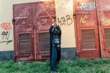 Çocuk bir kostüm Darth Vader kılıç ile.