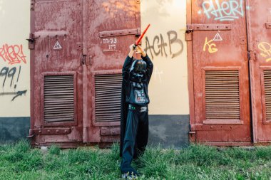 Çocuk bir kostüm Darth Vader kılıç ile.