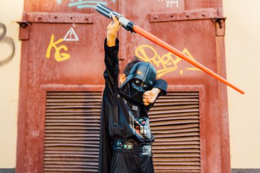 Çocuk bir kostüm Darth Vader kılıç ile.