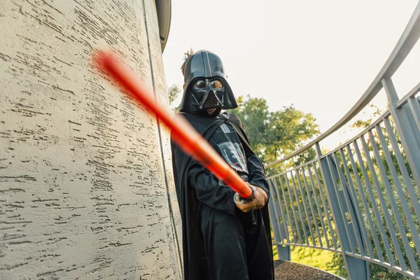 Çocuk bir kostüm Darth Vader kılıç ile.