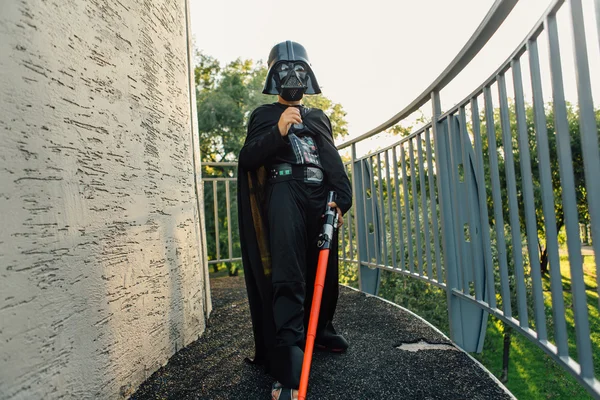 Çocuk bir kostüm Darth Vader kılıç ile.
