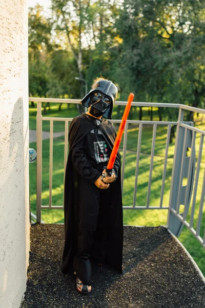 Çocuk bir kostüm Darth Vader kılıç ile.