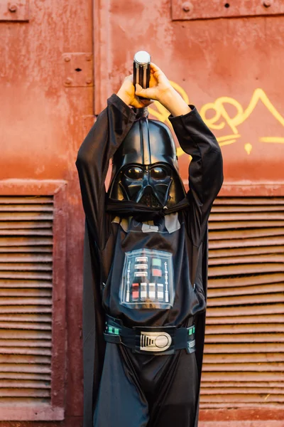 Çocuk bir kostüm Darth Vader kılıç ile.