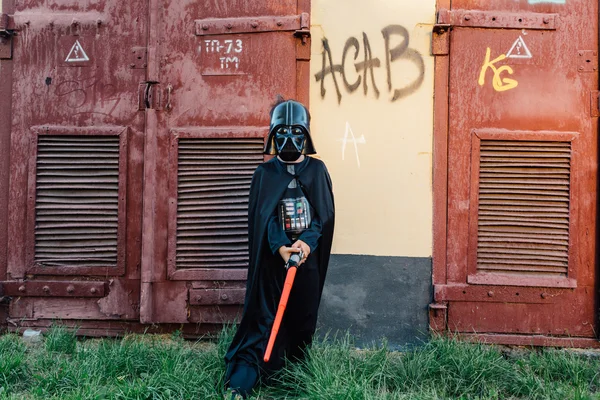 Çocuk bir kostüm Darth Vader kılıç ile.
