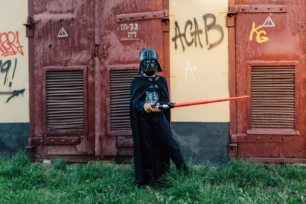 Çocuk bir kostüm Darth Vader kılıç ile.