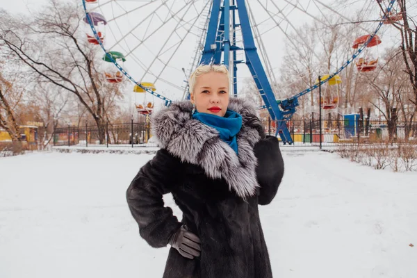 Blondes Mädchen im Pelzmantel nahe Riesenrad — Stockfoto