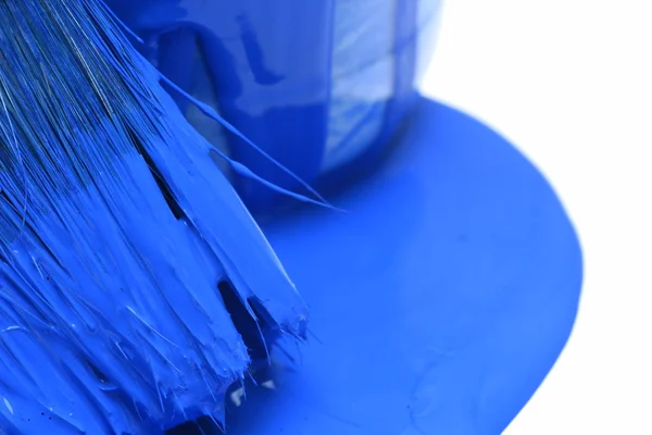 Крупный план синей банки краски с кистью на заднем плане — стоковое фото