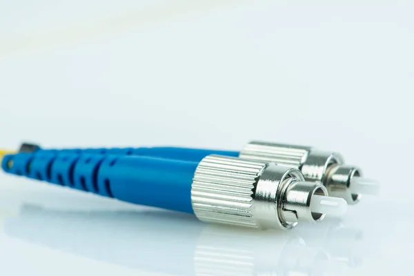 Close-up fiber optic single mode patch cord connector type FC with blurred background