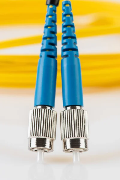 Close-up fiber optic single mode patch cord connector type FC with blurred background