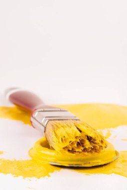 Açık sarı boya kutusunun kapağında kirli boya fırçası var.