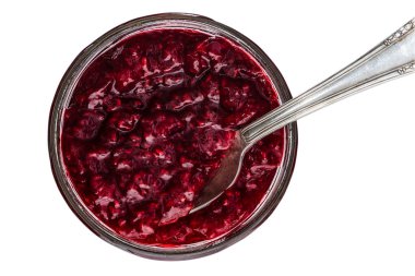 Ahududu reçeli kavanozu beyaz arka planda izole edilmiş gümüş kaşıkla yeni açıldı.