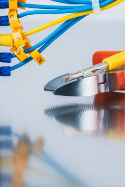 Metal plaka üzerinde pense ve kablo, elektrik tesisatları