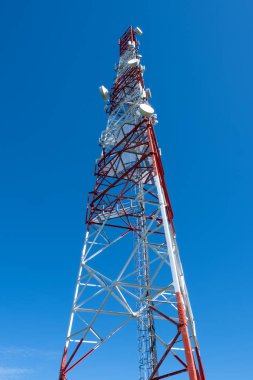Telecommunication tower against blue sky clipart